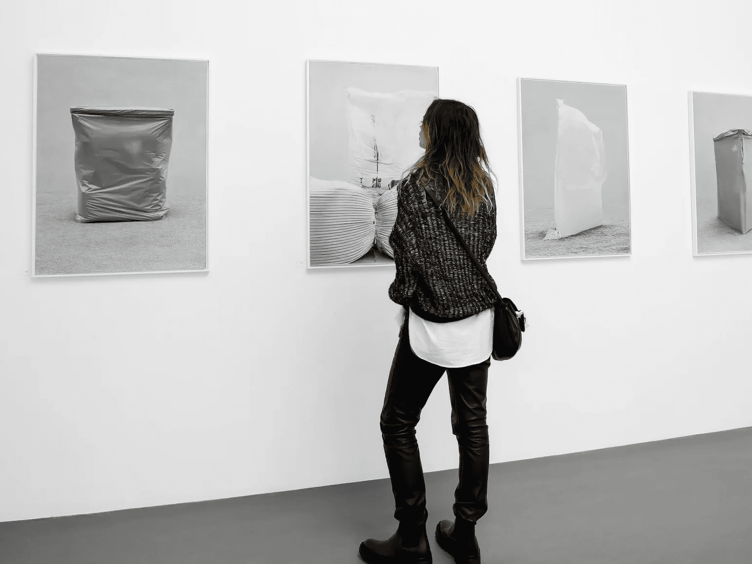 A visitor standing in front of large monochrome photographs in a gallery